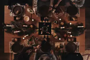 Eine Gruppe von Menschen sitzt um einen Tisch mit Essen.