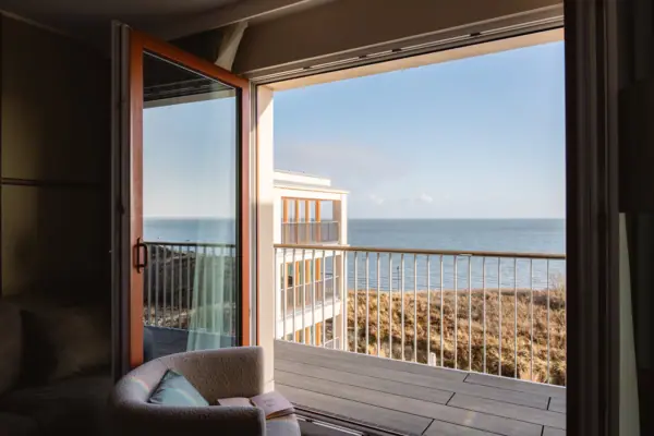 Ein Zimmer mit Balkon und Blick auf den Ozean.