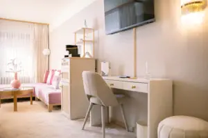 Ein Zimmer mit einem Schreibtisch und einem Fernseher.
