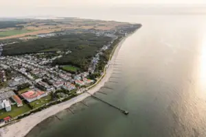 Strand mit Gebäuden und Bäumen aus der Vogelperspektive.