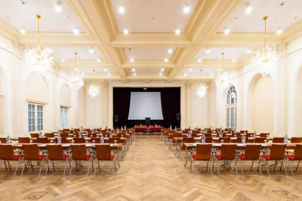 A-ROSA Veranstaltungsraum Weißer Saal Ein Saal mit vielen Stühlen und einer Projektionsleinwand im A-ROSA Travemünde.