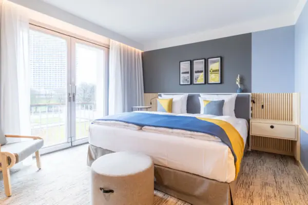 Ein Bett in einem Hotelzimmer mit eleganter Bettwäsche und Kissen.