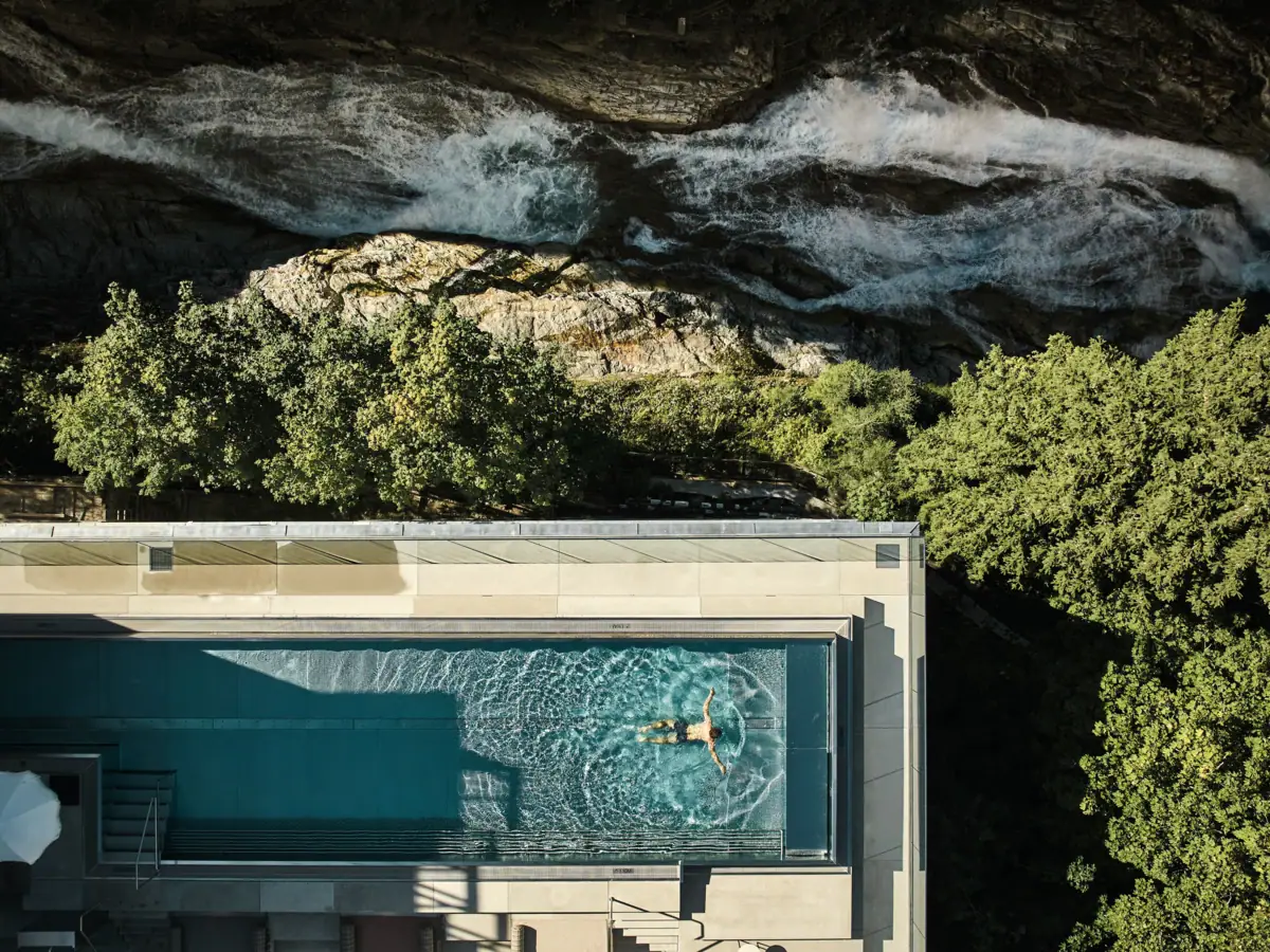 Person schwimmt in einem Pool im Freien.