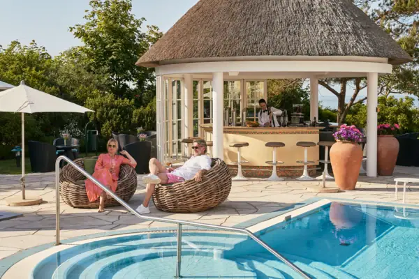 Gäste entspannen im Day SPA des A-ROSA Ostseehotel Kühlungsborn am Pool mit Terrasse und Strandkörben