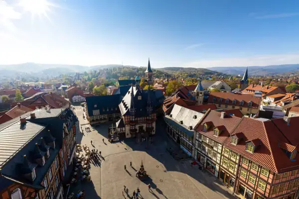 Ein Marklplatz mit vielen Fachwerk-Gebäuden unter einem blauen Himmel.