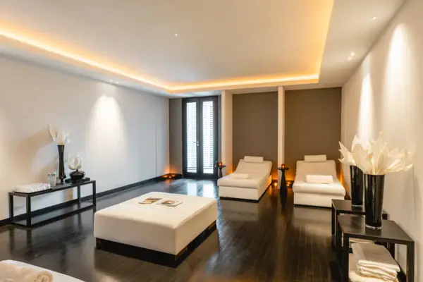 Ein Zimmer mit weißen Möbeln und einem schwarzen Tisch.