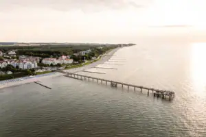 Ein langer Steg, der zu einem Strand führt.