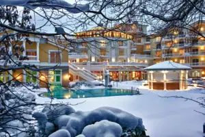 Ein Gebäude mit einem Pool im Schnee, umgeben von winterlicher Landschaft.