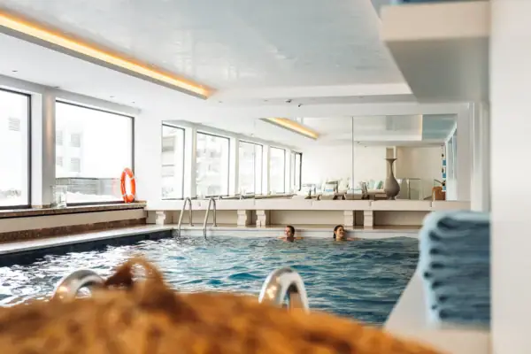 Menschen in einem Hallenbad mit großem Fenster.