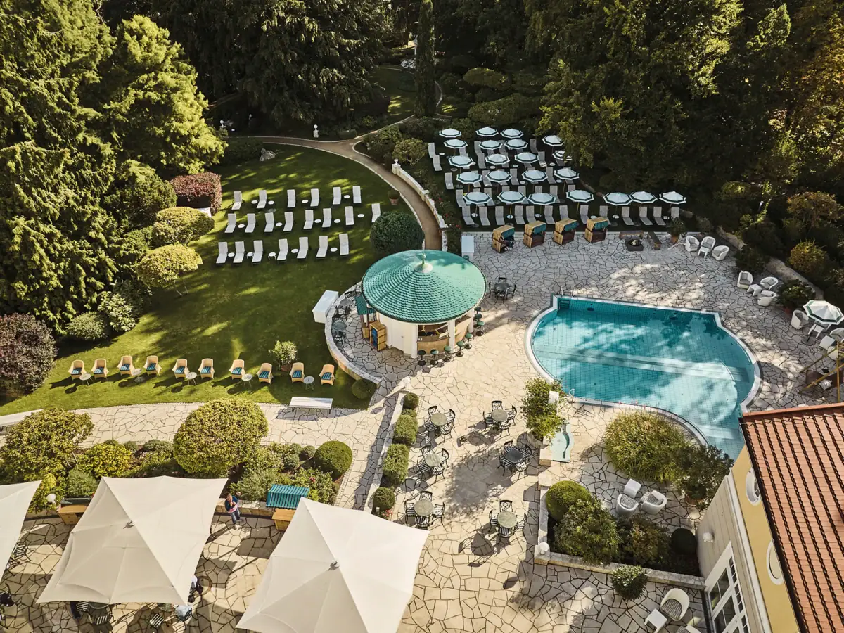 Ein Pool mit Liegestühlen in einem Garten.
