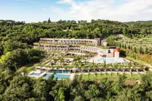 A-ROSA Hotel am Gardasee Ein Gebäude mit einem Pool, umgeben von Bäumen.