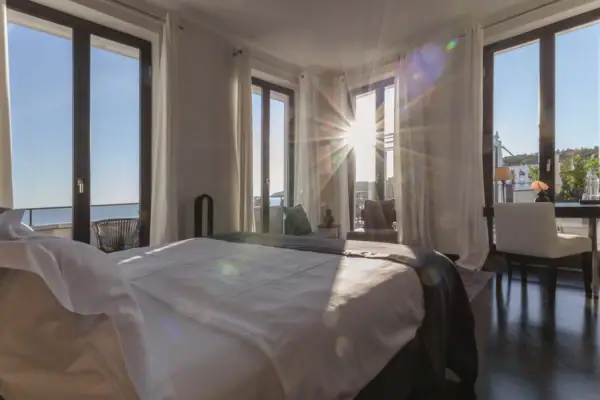 Ein Zimmer mit einem Bett und Fenstern.