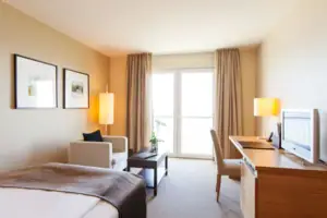 Ein Zimmer mit einem Bett, einem Schreibtisch und Stühlen.