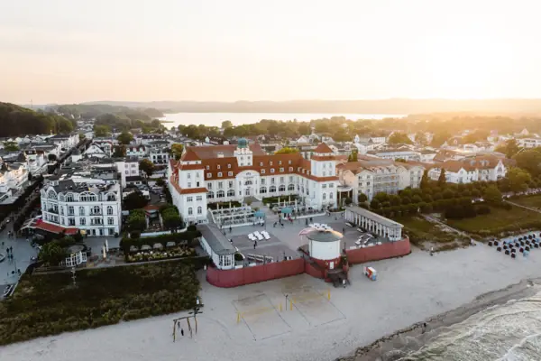 Strand mit Gebäuden und einem Gewässer im Hintergrund.