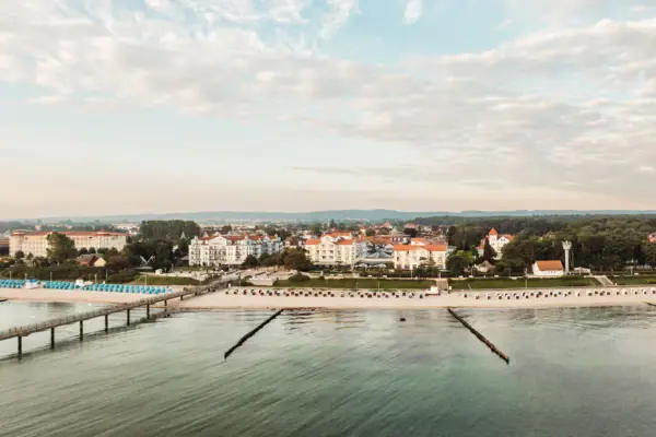 Ein Gewässer mit Gebäuden und Bäumen im Hintergrund.
