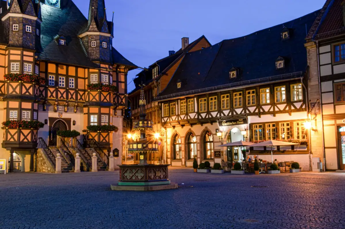 Gothisches Haus Wernigerode Ein Gebäude mit einem Brunnen davor.