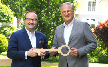 Marcus Scharon bekommt symbolisch den Schlüssel als Hoteldirektor im Strandidyll Heringsdorf von Detlev Kruse übergeben