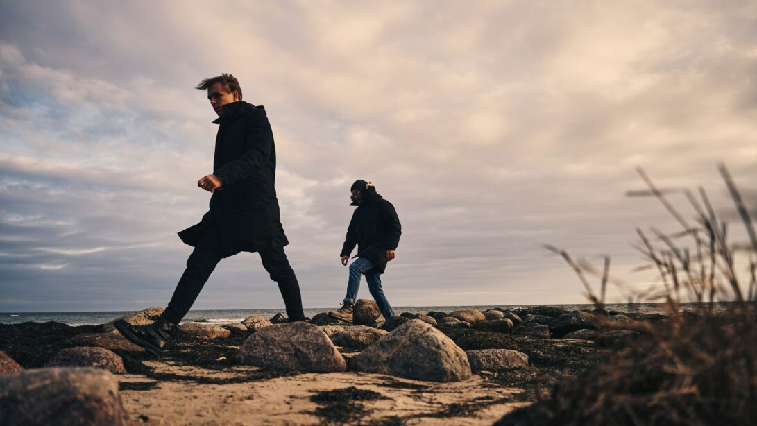 Männer spazieren am Strand