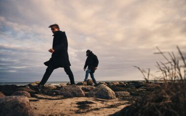 Männer spazieren am Strand