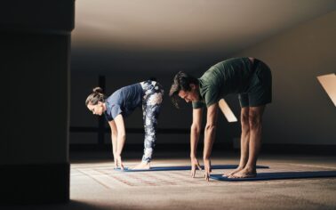 Mann und Frau dehnen sich beim Yoga in einem Dachboden